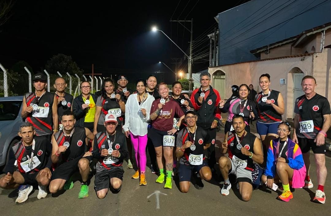 Equipe ACCB reunida à noite após corrida com medalhas e troféu
